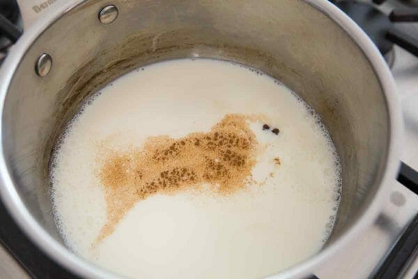  Нагрейте молоко для рецепта яичного гвоздика с корицей и гвоздикой. 